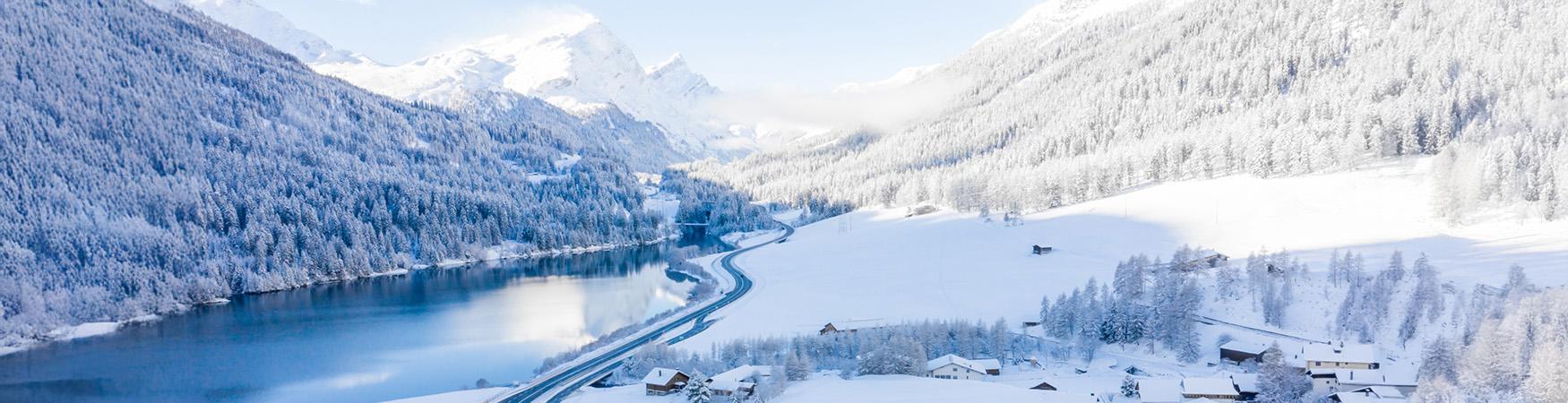 Winterlandschaft mit Bergen und Straße in der Schweiz